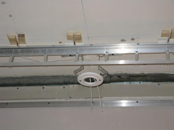 Первый этап монтажа натяжного потолка заключается в установке закладных. Закладные изготавливаются из пластика и в них есть отверстия для установки светильников