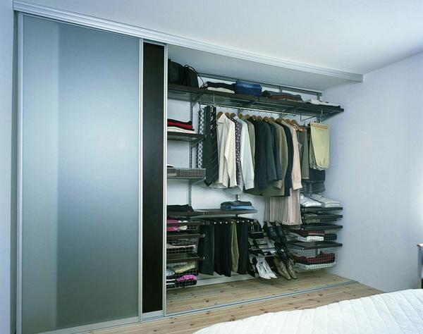 Если помещение выполнено в стиле хай-тек, то отличным вариантом для разделения гардеробной и комнаты является использование раздвижных дверей 
