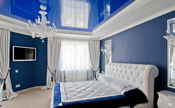 Синие обои в сочетании с белыми шторами хорошо вписываются в спальню, выполненную в классическом стиле 