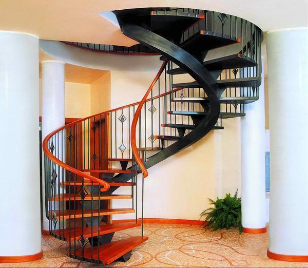 Интересно и необычно в интерьере гостиной будет смотреться винтовая металлическая лестница