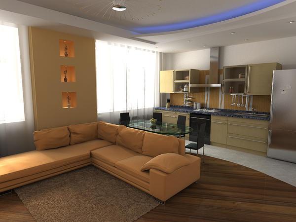 В помещении, объединяющем гостиную и кухню, часто используется зонирование при помощи отделочных материалов и световых акцентов