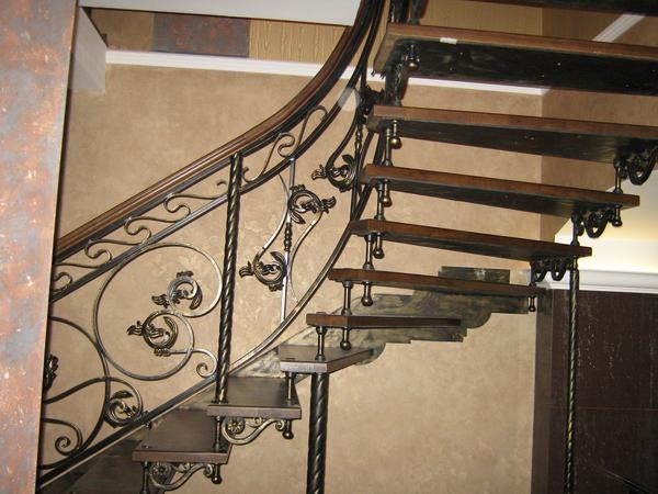 Кованные перила отлично смотрятся на любой лестнице, включая поворотную с забежными ступенями 