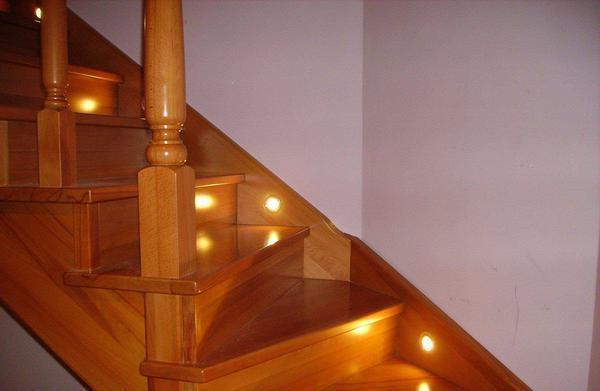 Освещать лестницу можно как с помощью люстры, так и точечными светильниками