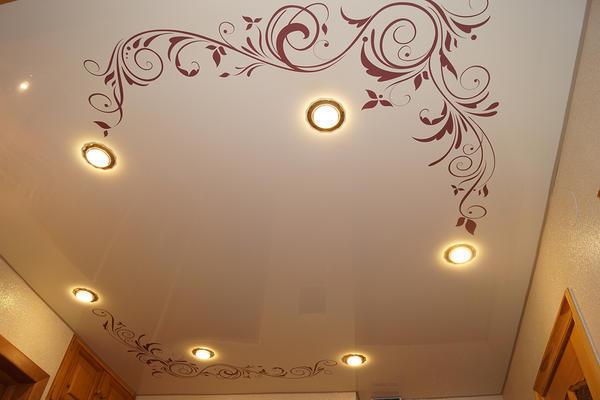 Встроенные светильники в натяжной потолок подходят лучше, чем громоздкая люстра