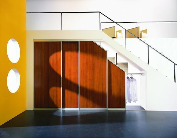 Выбирать шкаф под лестницу нужно такой, чтобы он гармонично вписывался в интерьер по стилю и цвету 