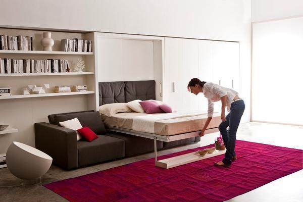 С помощью стеллажа спальню можно превратить в небольшой кабинет, а убирающаяся в шкаф кровать позволит создать зону для работы и чтения