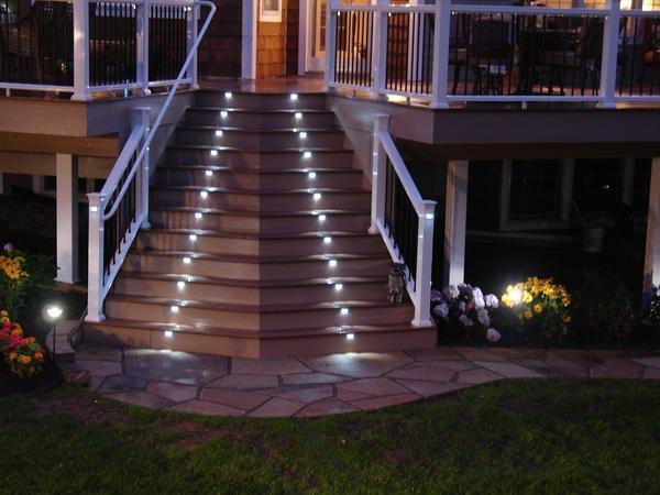 Отличным решением является освещение лестницы на улице точечными светильниками, которые монтируются на ступени