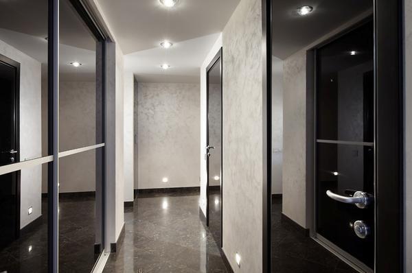 Обустраивая интерьер коридора с темными дверью и полом, обратите особое внимание на освещение