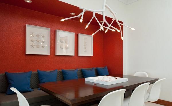 Сделать гостиную в красно-белом цвете интересной и оригинальной можно при помощи красивого текстиля или стильных элементов декора синего цвета
